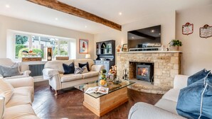 A cozy living room with a stone fireplace, a glass coffee table, and a comfortable sofa set.