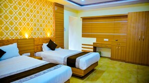A hotel room with two beds, wooden headboards, a large wardrobe, and a patterned wallpaper. - Hotel Star Holiday (Siddharthanagar)