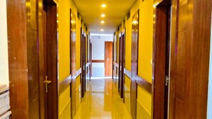 A corridor with wooden doors and a sign indicating room numbers 210 and 221. - Hotel Star Holiday (Siddharthanagar)