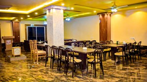 A conference room with a marble floor, multiple tables, and chairs. - Hotel Star Holiday (Siddharthanagar)