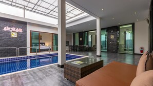 A modern hotel interior with a swimming pool, a lounge area, and a dining space. - 4 Bedroom Modern Pool Villa BL10 (Hua Hin)