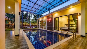 An indoor swimming pool with a glass ceiling, a restaurant area, and a view of the outdoors. - 4 Bedroom Modern Pool Villa BL10 (Hua Hin)