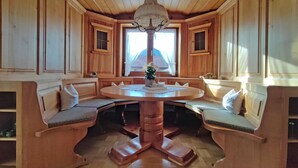 Una habitación con paneles de madera, una mesa redonda y bancos.