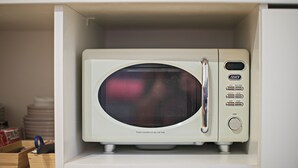 Um micro-ondas numa cozinha embutido no armário.