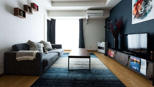 A modern living room with a sofa, coffee table, and TV. - AMS TOWER (Sapporo)