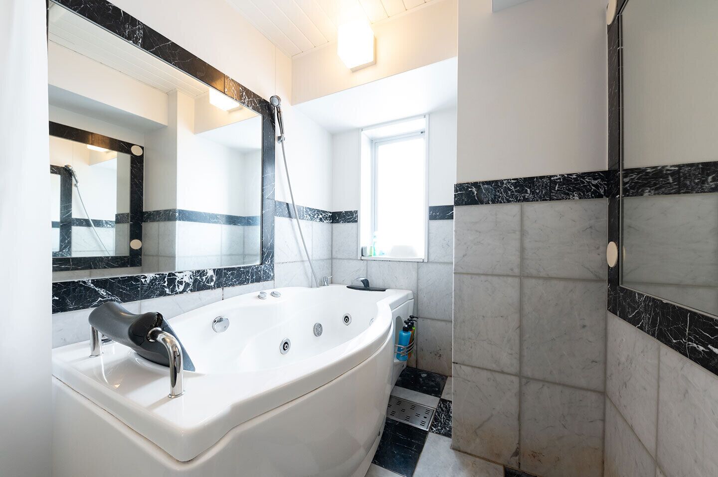 A modern bathroom with a freestanding bathtub, a large mirror, and a shower area.