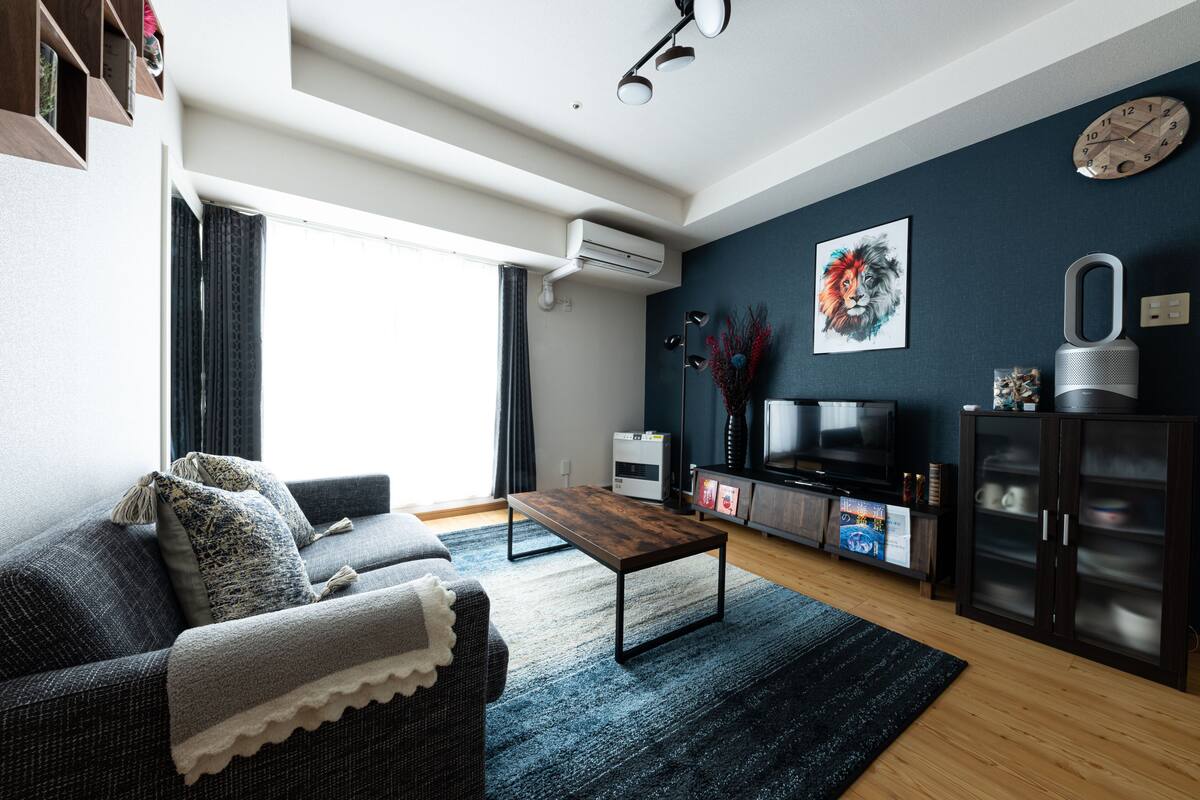 A modern living room with a sofa, coffee table, and entertainment unit.
