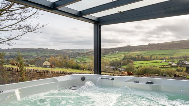 A hot tub with a view of a rural landscape. - The Lee - Luxury Cottages (Keighley)