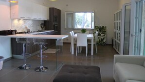 Une cuisine moderne dotée d’un îlot central, de tabourets de bar et de luminaires suspendus.