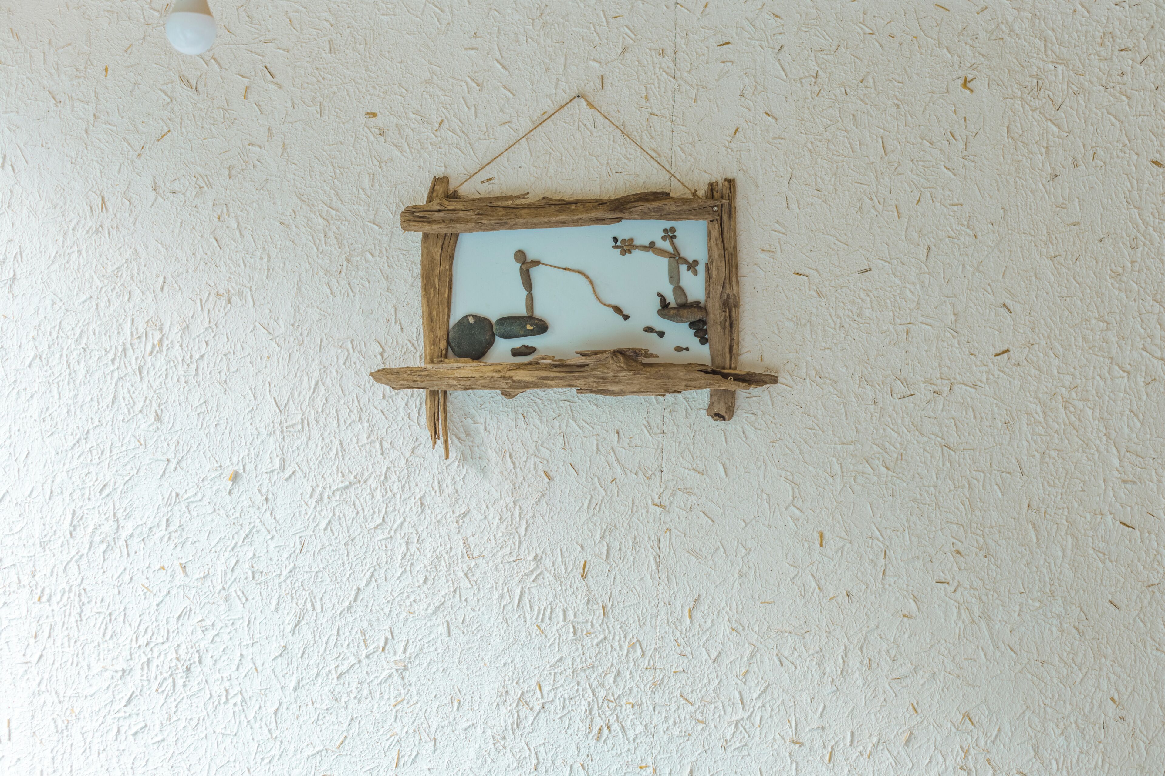 A rustic wooden frame hanging on a textured wall.