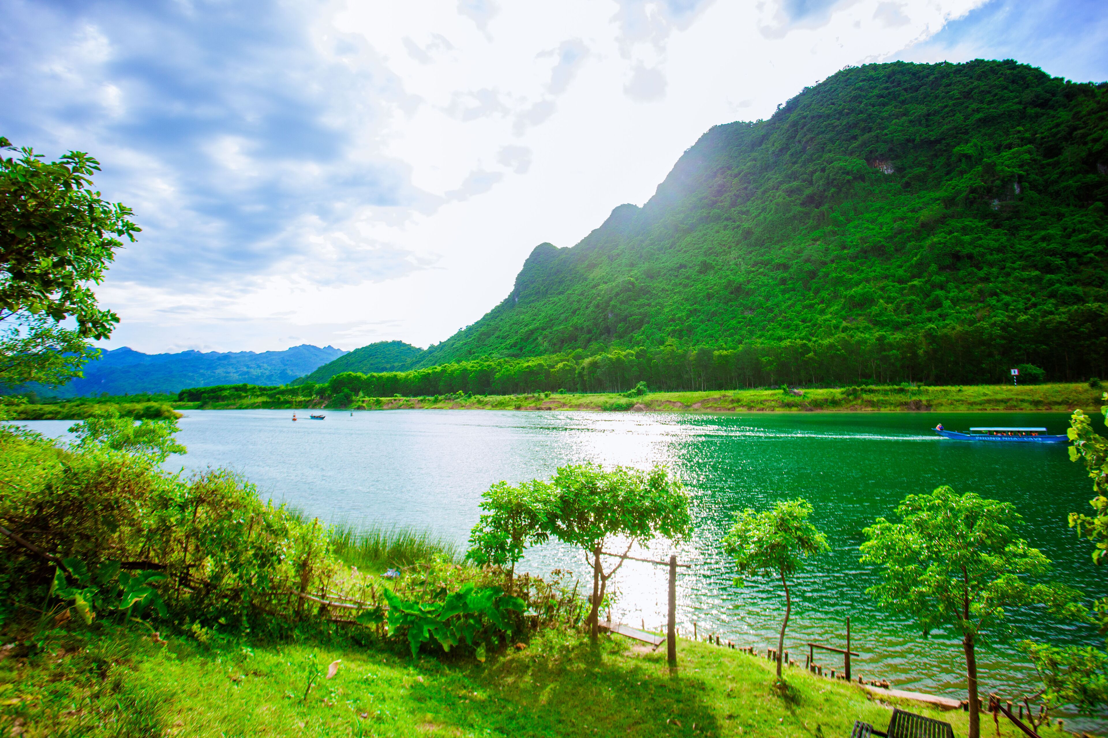 A serene lake surrounded by lush greenery and hills.