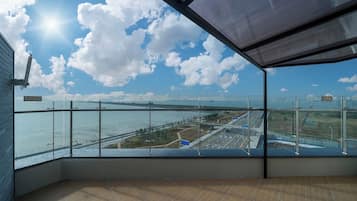 Ein Zimmer mit einem großen Fenster, das auf eine Brücke und ein Gewässer blickt.