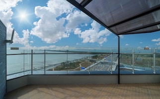 Una habitación con un ventanal grande que da a un puente y una masa de agua.