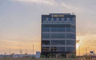 A modern hotel building with a sign reading 'BROWN DOT HOTEL' at the top.