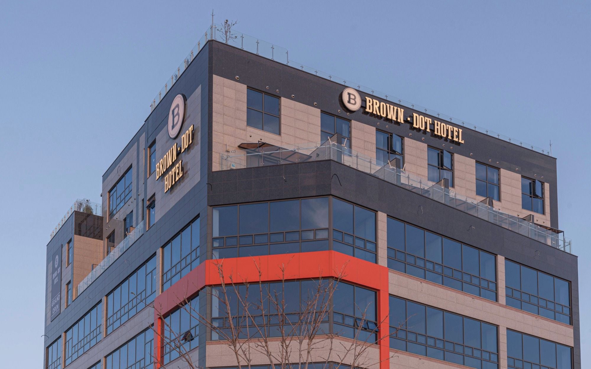 Un moderno edificio de hotel con un llamativo letrero que dice 'BROWN - DOT HOTEL'.