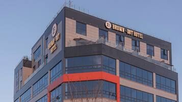Un moderno edificio de hotel con un llamativo letrero que dice 'BROWN - DOT HOTEL'.