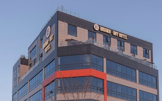 A modern hotel building with a prominent 'BROWN - DOT HOTEL' sign.