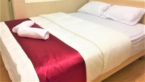 A hotel room with a bed, a window, and a red and white bedspread. - BLOOMINGTON (Surabaya)