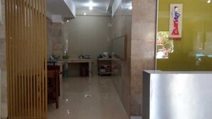 A bathroom with a wooden partition, a sink, and a mirror. - BLOOMINGTON (Surabaya)