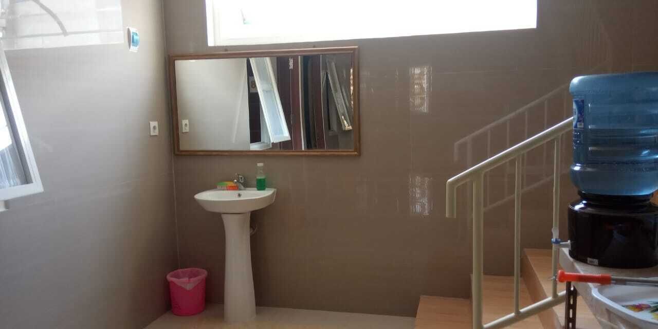 Une salle de bain équipée d’un lavabo, d’un miroir et d’un distributeur d’eau.