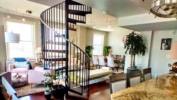 A spacious living area with a spiral staircase, a dining area, and a kitchen with a granite countertop. - Lush Rooftop Terrace  City views A luxurious stay in  Central Downtown Area
 (Louisville)