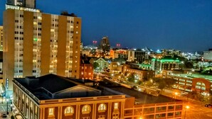 A cityscape at night with illuminated buildings and a clear view of a large, historic building with arched windows and a flat roof. - Lush Rooftop Terrace  City views A luxurious stay in  Central Downtown Area
 (Louisville)