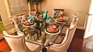 A dining table set with red and white plates, green glassware, and a potted plant. - Lush Rooftop Terrace  City views A luxurious stay in  Central Downtown Area
 (Louisville)