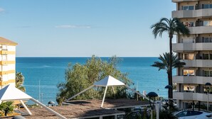 A beachfront view with a white tent and a building with balconies overlooking the sea. - Seaview beachfront studio with aqua park & balcony REF007 (Benalmádena)