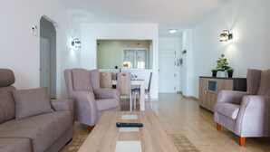 Un salon moderne avec un canapé, des fauteuils et une table basse.