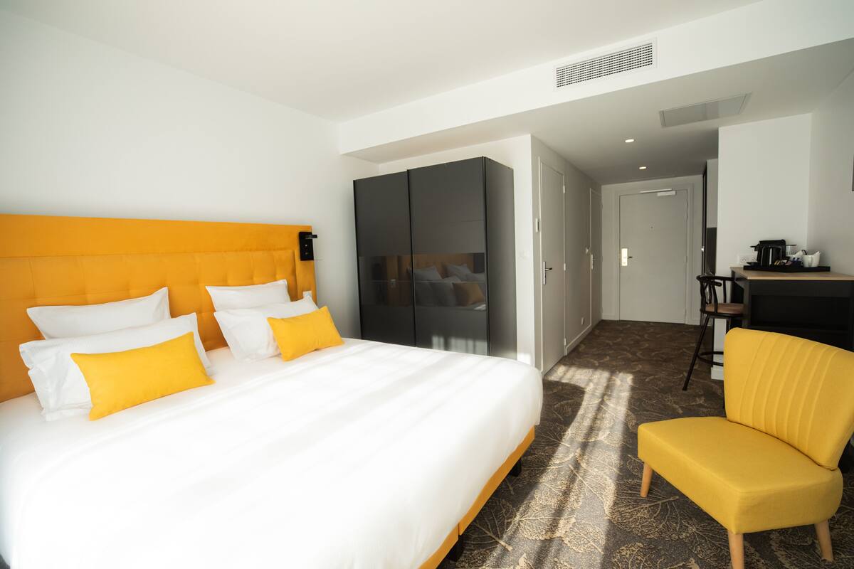 Une chambre d’hôtel avec un grand lit, un bureau et une chaise.