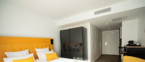 Una habitación de hotel con una cama grande, un escritorio y una silla.
