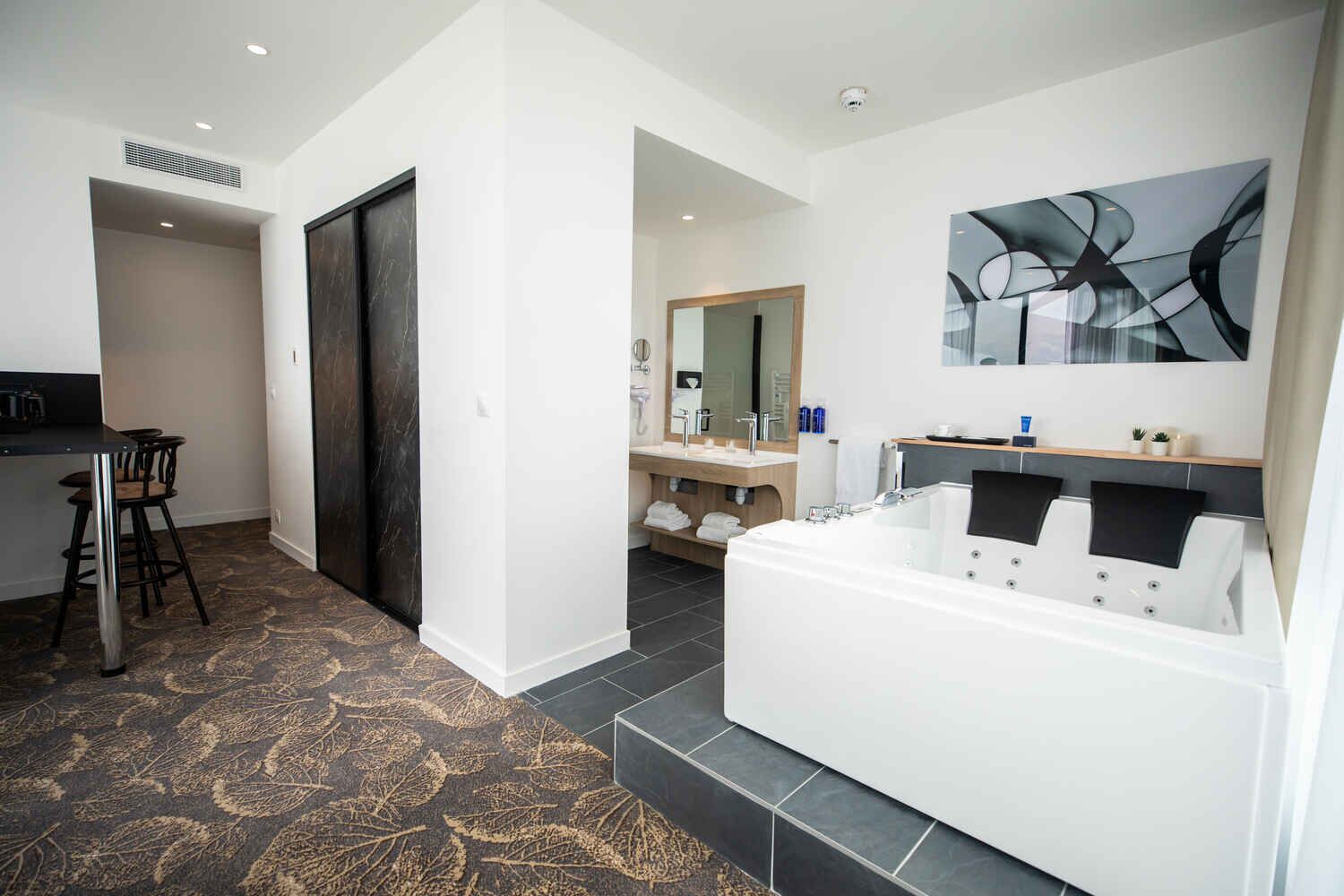 Une salle de bain moderne dotée d’une grande baignoire, d’une douche séparée et d’un meuble-lavabo avec un miroir.