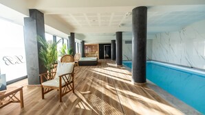 A spacious indoor area with a wooden floor, a pool, and seating areas. - Hôtel Barracuda & Spa, Centre Port, pieds dans l'eau, vue mer (Brest)