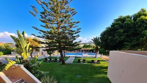 A pool area with lounge chairs and a clear view of a swimming pool. - Abella Hotel (Chania)