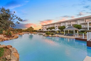 Relax by the tranquil pool surrounded by lush gardens and enjoy the resort's modern architecture.