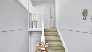 A staircase with wooden steps and white walls, leading to a door. - Sunset Lake House - Pool, Lake Views & Beach (The Entrance North)