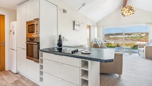 Uma cozinha moderna com eletrodomésticos embutidos, sala de jantar com vista e um espaço de estar aconchegante.