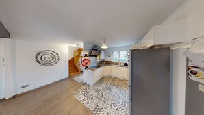 Una cocina moderna con una escalera de madera, horno empotrado y alfombra estampada.