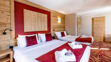 Une chambre d’hôtel avec deux lits, des têtes de lit en bois, des murs rouges et une moquette à motifs.