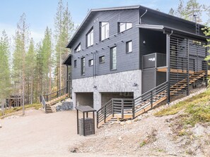 A modern two-story building with a stone facade and a wooden deck. - Villa arcus a by Interhome (Pelkosenniemi)