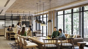 Un espace de repas moderne, doté de meubles en bois, de luminaires suspendus et de grandes fenêtres laissant entrer la lumière naturelle.