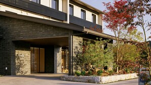 Un bâtiment moderne avec une façade en briques, de grandes fenêtres et une entrée abritée.