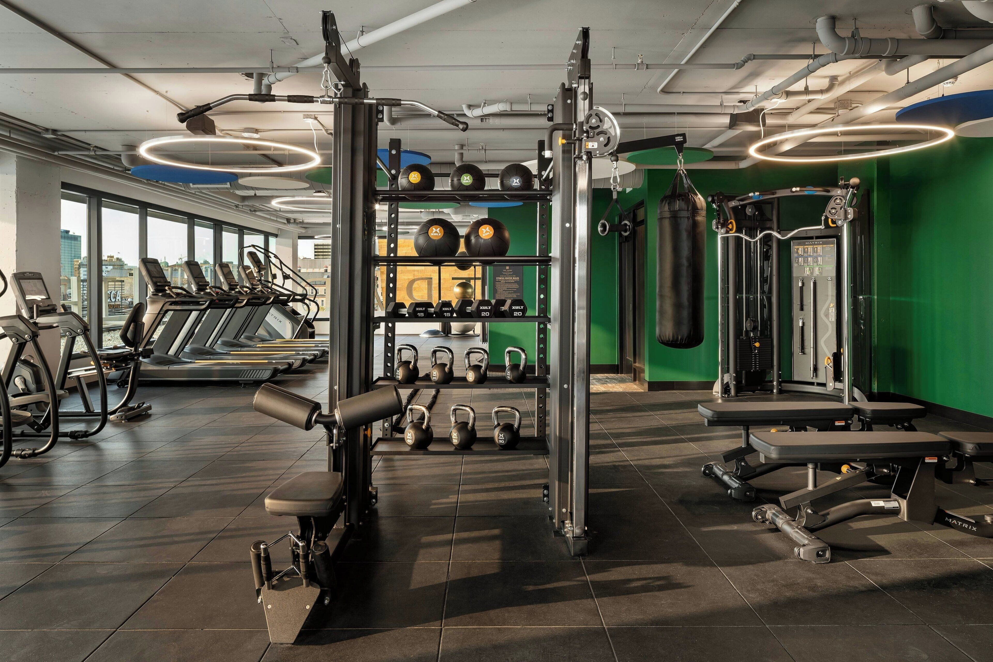 Una palestra con tapis roulant, macchinari per pesi, kettlebell e un sacco da boxe.
