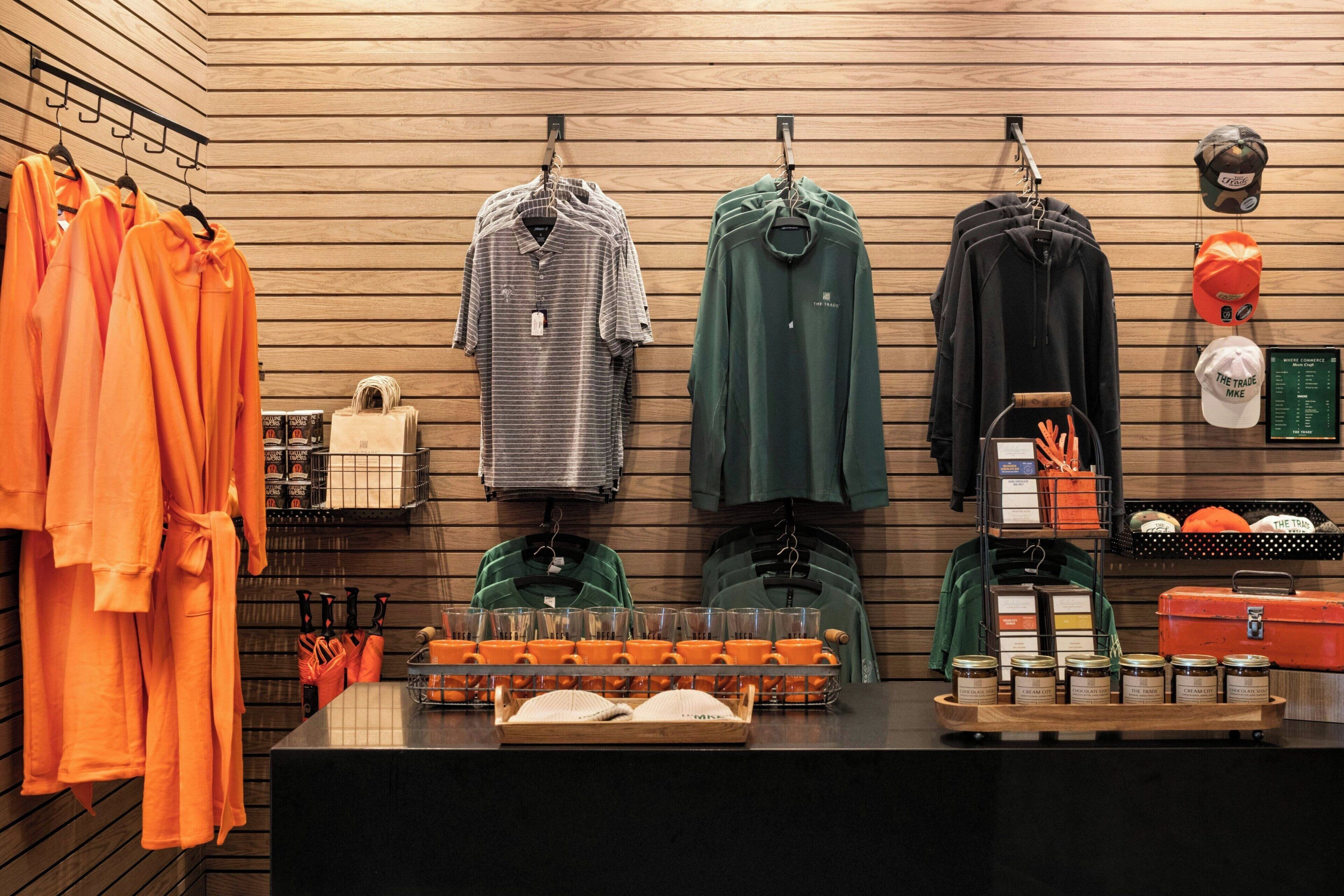 A retail store with various clothing items and accessories displayed on racks and shelves.