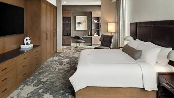 Une chambre d’hôtel avec un grand lit, une armoire en bois, un téléviseur à écran plat et un espace bureau avec une chaise.