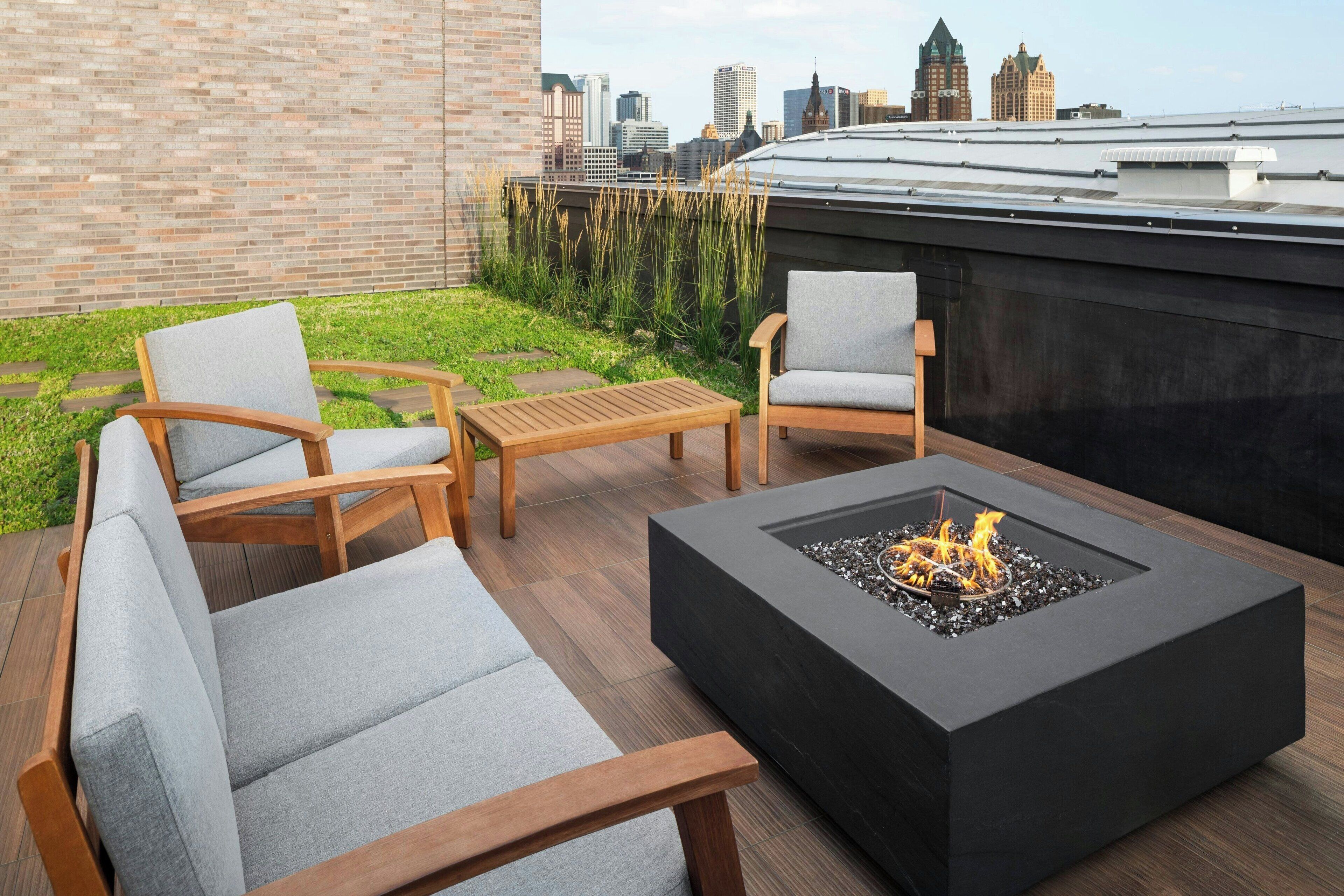 Una terrazza sul tetto con un braciere, zona salotto e vista sullo skyline della città.