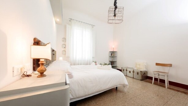 A bedroom with a bed, bedside table, lamp, and a hanging light fixture. - CASA AMELIE - APARTMENT IN FLORENCE FREE WIFI + ETHERNET (Firenze)