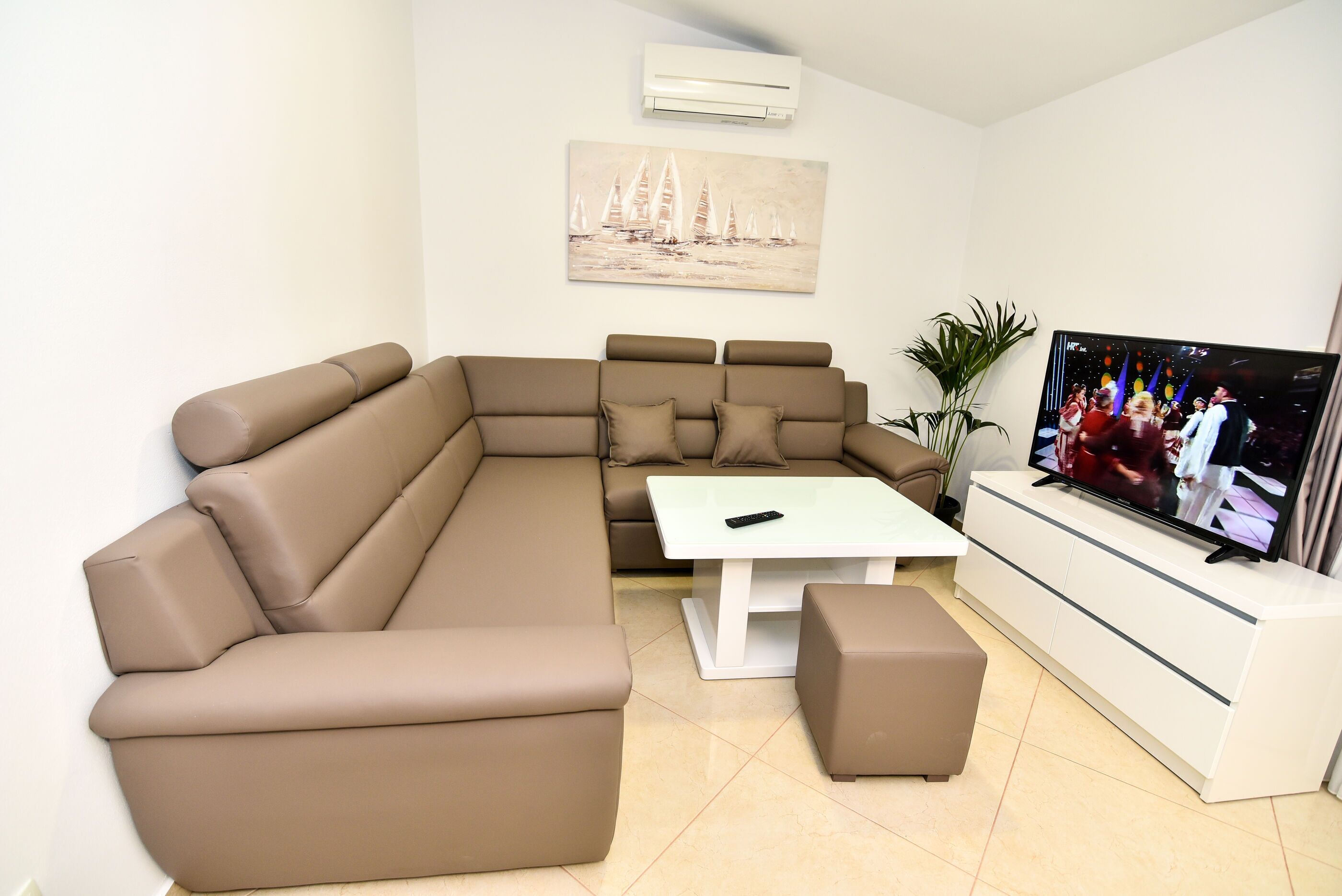 A modern living room with a sectional sofa, a coffee table, and a TV.