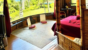 Ein Zimmer mit einem Bett, einem kleinen Tisch und Blick ins Freie.