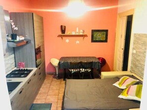 A compact room with a kitchenette, a dining table, and a bed. - "La casa di Luna 2 city center Catania" + bike (Catania)